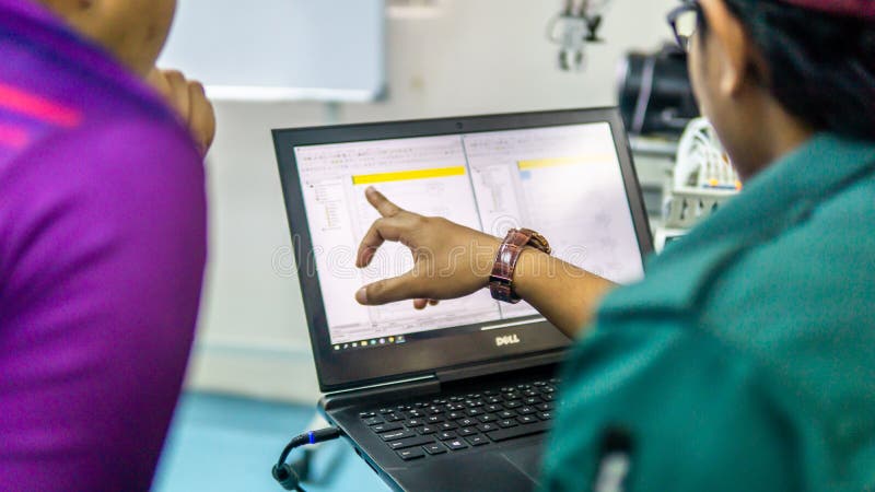 Engineering students discussing and solving the task given on the automation machine system in the laboratory royalty free stock photography