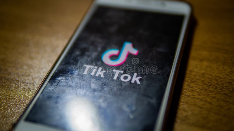 Close up view of the Tik Tok logo on an android smartphone with wooden table background stock image