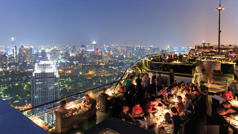 Bangkok par la nuit vue d'une barre de dessus de toit avec beaucoup de touristes appréciant la scène photo libre de droits Bangkok par la nuit vue d'une barre de dessus de toit avec beaucoup de touristes appréciant la scène photo libre de droits