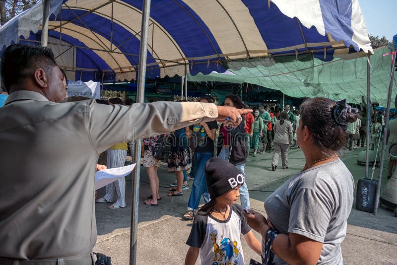 BANGKOK, TAILANDIA - 17 DE MARZO: Ciudadanos civiles de las ayudas del trabajador a la línea correcta a hacer cola para la elecci imagenes de archivo BANGKOK, TAILANDIA - 17 DE MARZO: Ciudadanos civiles de las ayudas del trabajador a la línea correcta a hacer cola para la elecci imagenes de archivo