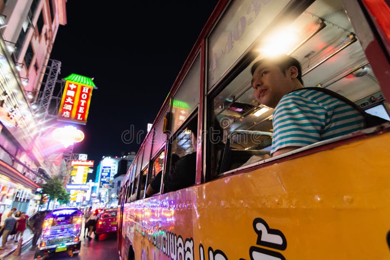 BANGKOK TAJLANDIA, MARZEC, - 2019: mężczyzna jedzie publicznie autobus przez Porcelanowego grodzkiego noc rynku fotografia royalty free BANGKOK TAJLANDIA, MARZEC, - 2019: mężczyzna jedzie publicznie autobus przez Porcelanowego grodzkiego noc rynku fotografia royalty free