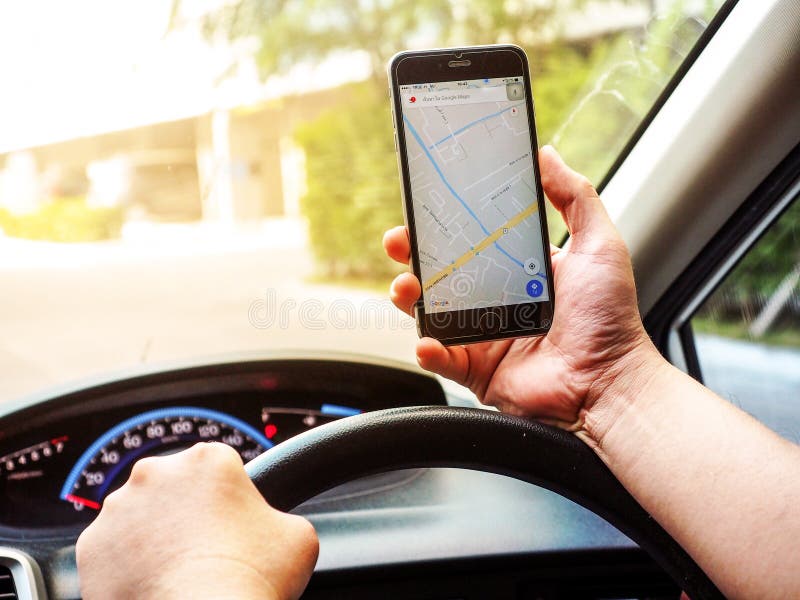 BANGKOK, THAILAND - 24 APRIL 2017: Close up of man holding smartphone in car, Google Maps is used to navigate a journey while royalty free stock photo BANGKOK, THAILAND - 24 APRIL 2017: Close up of man holding smartphone in car, Google Maps is used to navigate a journey while royalty free stock photo