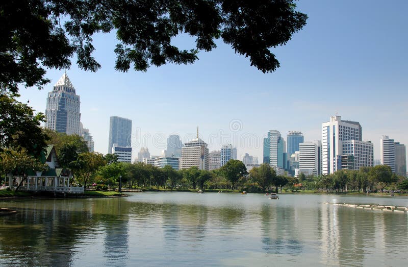 View across the tranquil boating lake in Lumphini Park to the Sala Daeng-Silom Road commercial district skyline in Bangkok, Thailand - Xu Lei Photo. View across the tranquil boating lake in Lumphini Park to the Sala Daeng-Silom Road commercial district skyline in Bangkok, Thailand - Xu Lei Photo.