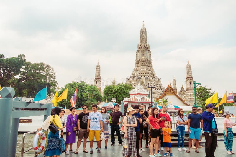 Group of travellers standing on the pontoon waiting for a boat at Wat Arun pier. Bangkok, Thailand. stock photos Group of travellers standing on the pontoon waiting for a boat at Wat Arun pier. Bangkok, Thailand. stock photos