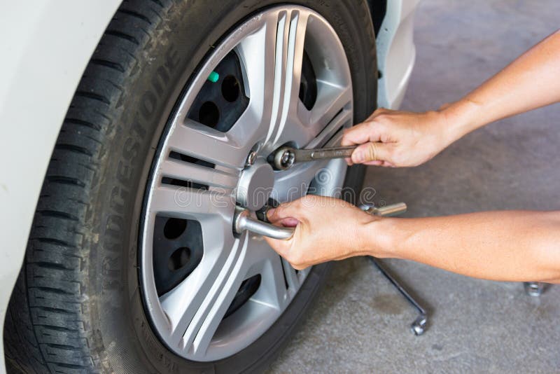 Car mechanician changing tire car wheel in auto repair shop