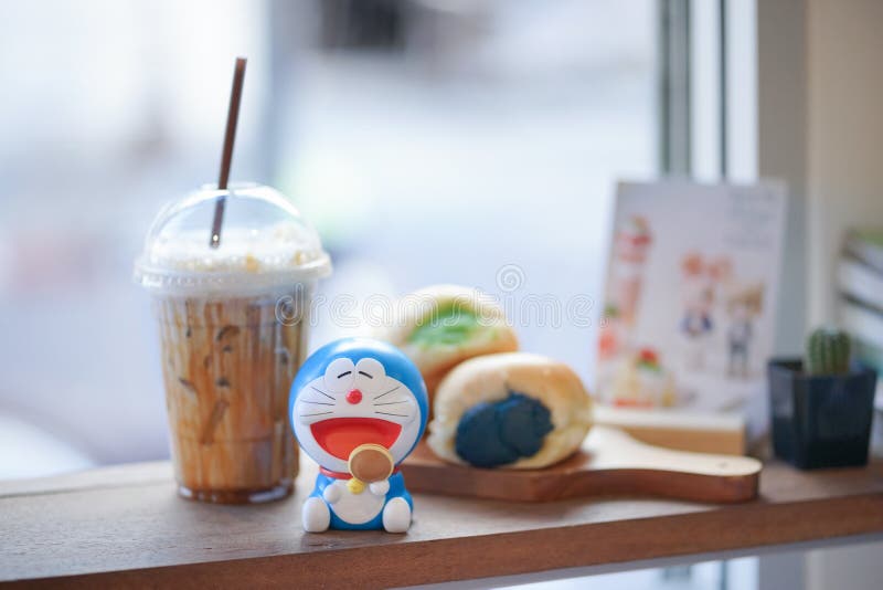 Bangkok, Thailand - Feb 16, 2020 : A toy photography of Doraemon happily eating dorayaki. Doraemon is a worldwidely famous cat robot cartoon character from Japan. Dorayaki is his favourite snack