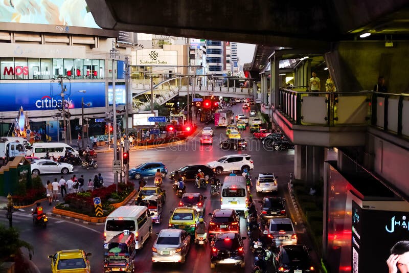 Bangkok, Thailand - January 04 2020 : Many cars, bus and motorcycles at Sukhumvit road, Ratchadaphisek road and Asok Montri road or Terminal 21 Intersection. People walking on overpass and sidewalk