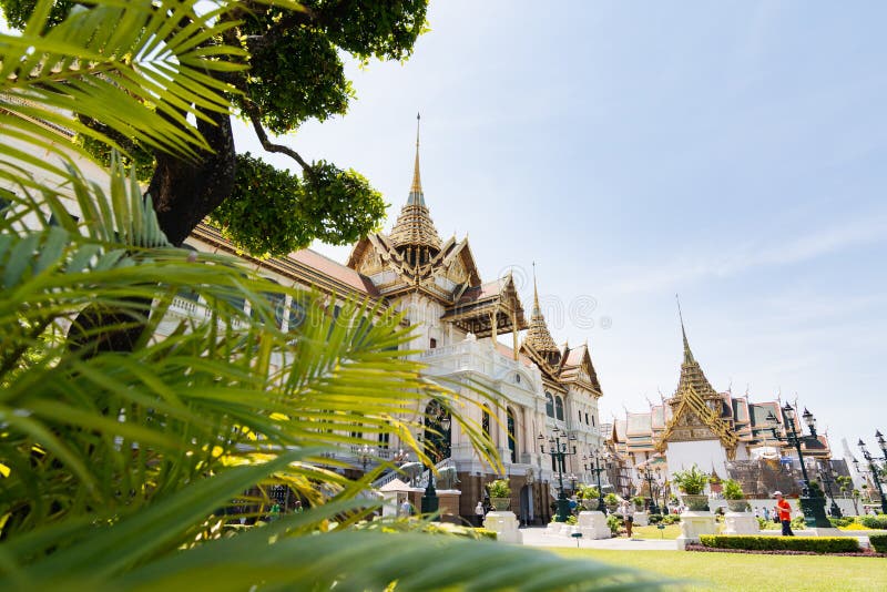 BANGKOK, THAILAND - MÄRZ 2019: Ansicht über großartige Palast- und Chakri-Maha Prasat Halle durch die Bäume und die Büsche stockfotografie BANGKOK, THAILAND - MÄRZ 2019: Ansicht über großartige Palast- und Chakri-Maha Prasat Halle durch die Bäume und die Büsche stockfotografie