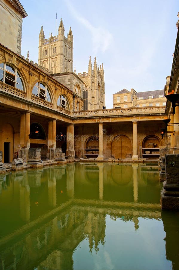 Ancient Roman Baths at Bath England at dusk. Bath Abbey can be seen behind. Ancient Roman Baths at Bath England at dusk. Bath Abbey can be seen behind.