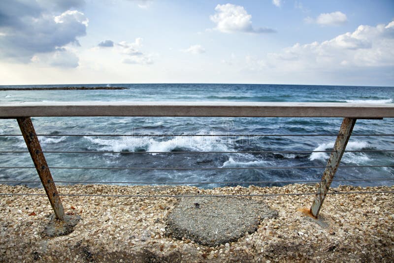 A banister attached to a wall, keeping people safe from falling to the gushing sea. A banister attached to a wall, keeping people safe from falling to the gushing sea.