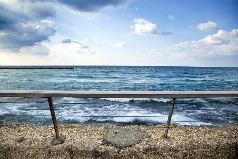 A banister attached to a wall, keeping people safe from falling to the gushing sea. A banister attached to a wall, keeping people safe from falling to the gushing sea.