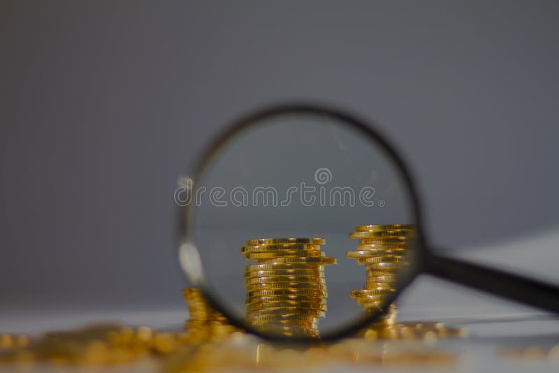 Banking and finance concept, coins with a microscope looking at it royalty free stock photography