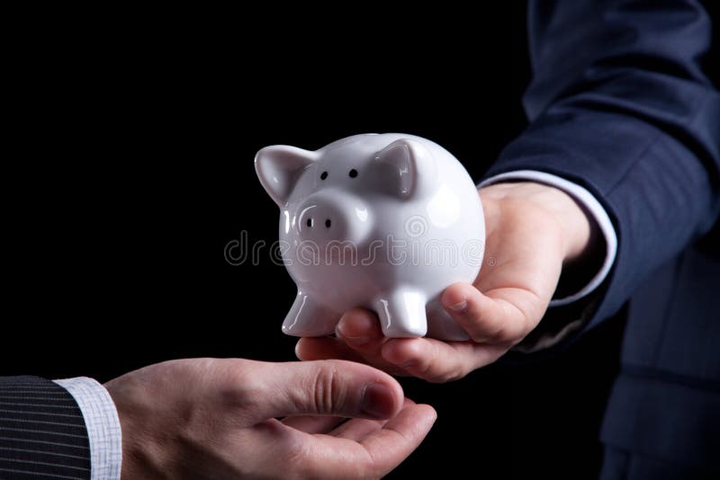 Businessman giving a piggy bank to you (isolated on black). Businessman giving a piggy bank to you (isolated on black)