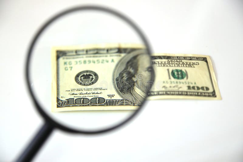 Banknotes Spread Out on a Table with a Calculator and a Magnifying