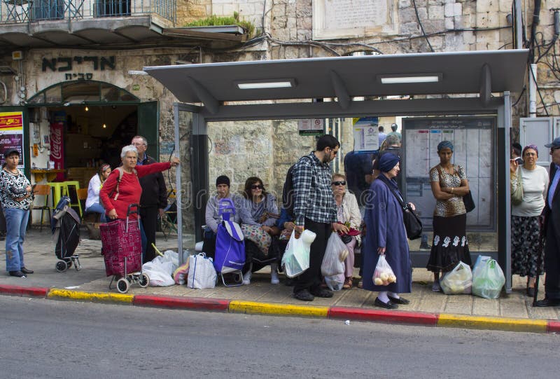 Banlieusards attendant un autobus dans un abri de bus local sur Shmuel Barukh Street près du marché en plein air de Mahane Yehuda photos libres de droits Banlieusards attendant un autobus dans un abri de bus local sur Shmuel Barukh Street près du marché en plein air de Mahane Yehuda photos libres de droits