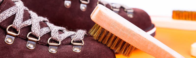 Banner of Brown man suede boots with brush. Macro. Clean shoes