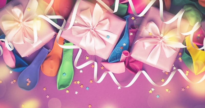 Banner Decorative box composition with gifts satin ribbon bow inflatable balls serpentine purple background A top view royalty free stock images Banner Decorative box composition with gifts satin ribbon bow inflatable balls serpentine purple background A top view royalty free stock images