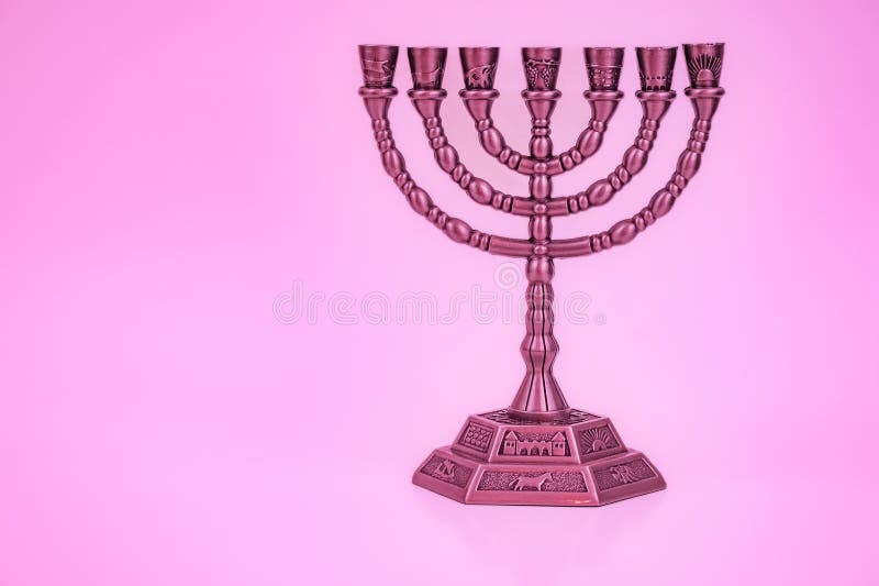 Ancient ritual candle menorah on a pink background. Jewish holiday banner with copy space. Ancient ritual religious candle menorah. Seven branched menorah. Seven lamps, light of God. Nobody. Ancient ritual candle menorah on a pink background. Jewish holiday banner with copy space. Ancient ritual religious candle menorah. Seven branched menorah. Seven lamps, light of God. Nobody