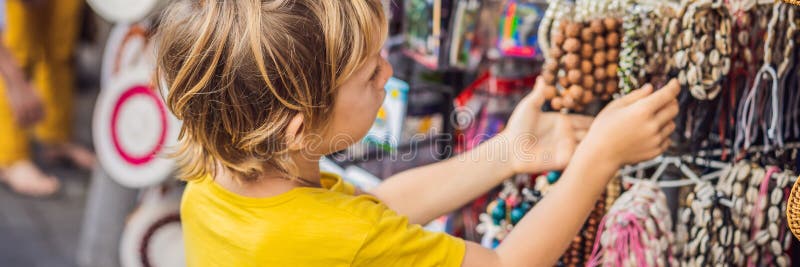 BANNER, LONG FORMAT Boy at a market in Ubud, Bali. Typical souvenir shop selling souvenirs and handicrafts of Bali at royalty free stock photography BANNER, LONG FORMAT Boy at a market in Ubud, Bali. Typical souvenir shop selling souvenirs and handicrafts of Bali at royalty free stock photography
