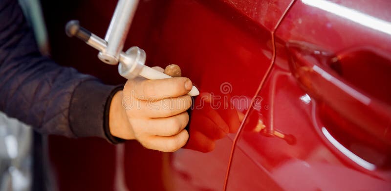 Banner Master auto mechanic removal of dents defects without painting on car body on service station.
