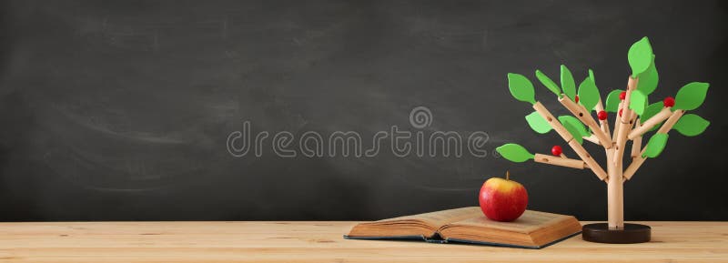 banner of open book and wooden tree puzzle over blackboard background. education and knowledge concept. royalty free stock photo banner of open book and wooden tree puzzle over blackboard background. education and knowledge concept. royalty free stock photo