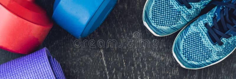 BANNER Yoga mat, sport shoes, dumbbells and bottle of water on blue background. Concept healthy lifestyle, sport and diet. Sport e