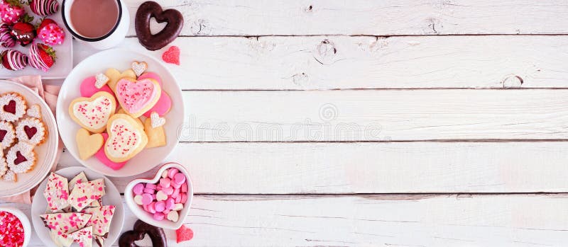 Bannière de jour de valentin avec la bordure latérale des bonbons et des biscuits triés, au-dessus de la vue sur un fond en bois photographie stock