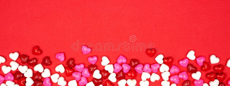 Bannière de jour de valentin avec la frontière de coeurs de bonbons sur un fond rouge avec l'espace de copie photos stock