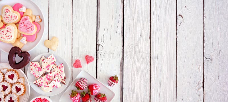 Bannière de jour de valentin avec la frontière du coin des bonbons et des biscuits triés, au-dessus de la vue sur un fond en bois images stock
