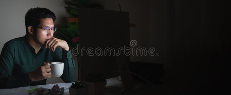 Bannière du café potable de jeune homme asiatique attirant se reposant sur la table de bureau regardant l'ordinateur portable dan images libres de droits Bannière du café potable de jeune homme asiatique attirant se reposant sur la table de bureau regardant l'ordinateur portable dan images libres de droits