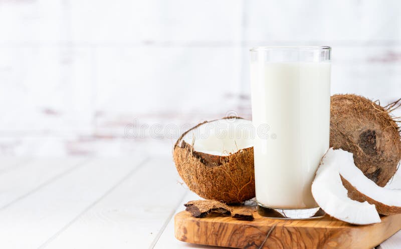 Bannière lait de coco sur table en bois blanc. Lait de coco végétalien non laitier dans différentes bouteilles avec espace de copie