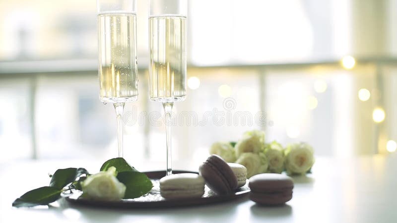 Banquete de boda lujoso del champán con las rosas blancas y los postres del macaron, celebración del día de fiesta