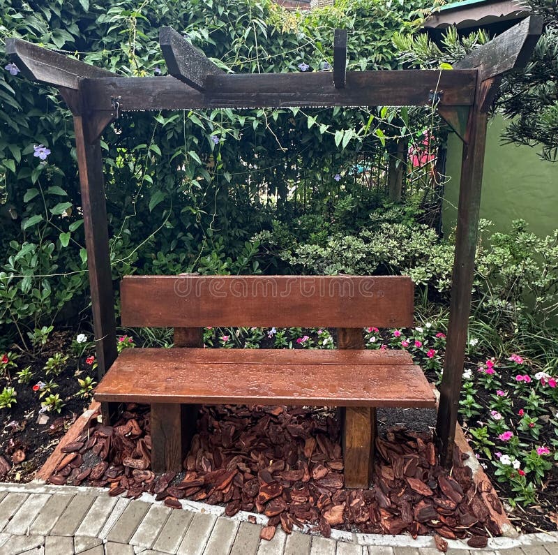 Banquette en bois située dans un jardin avec une barre en bois au-dessus images stock