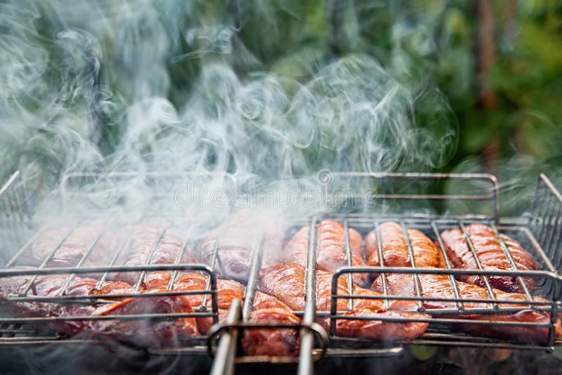 Barbacoa con salchichas de fuego en la parrilla. salchichas crudas cevapcici a la parrilla ha abierto fuego en la calle. foco sele foto de archivo