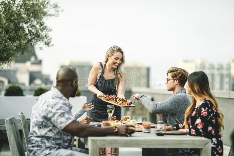 Barbacoa del vegano de la porción de la mujer a sus amigos imagen de archivo Barbacoa del vegano de la porción de la mujer a sus amigos imagen de archivo