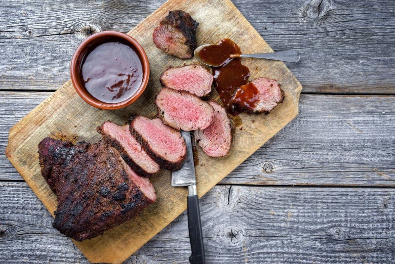 Barbacoa wagyu seco tri steak con salsa bbq como chapuzón en una tabla de corte de madera foto de archivo Barbacoa wagyu seco tri steak con salsa bbq como chapuzón en una tabla de corte de madera foto de archivo