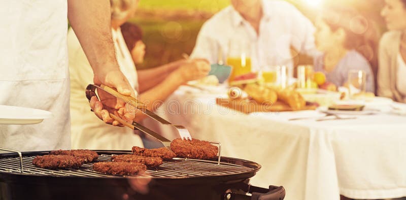 Barbecue grill with extended family having lunch in park