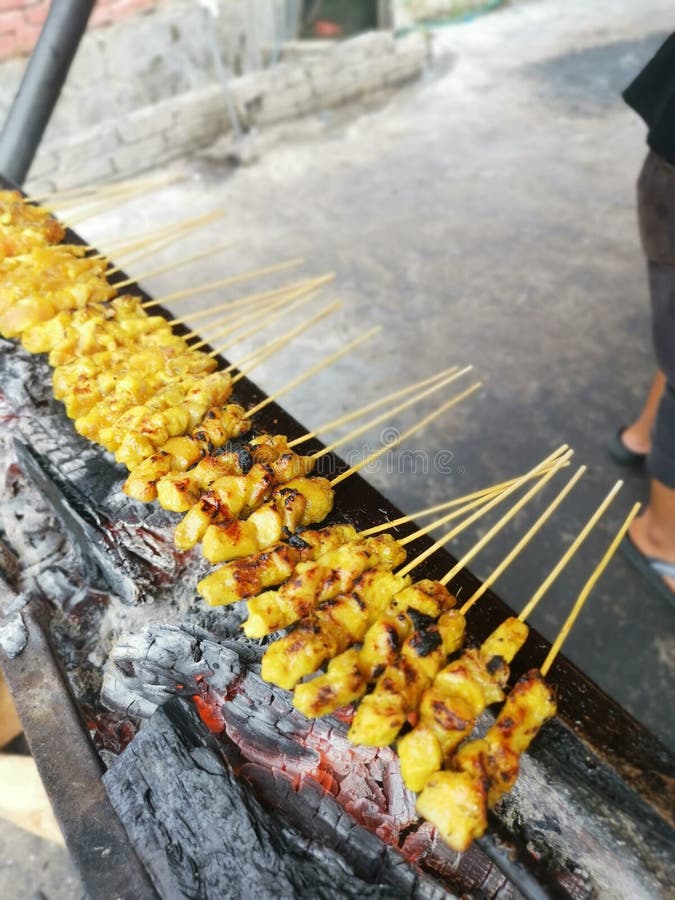 Barbecuing Sticks of Marinated and Bitesize Pieces of Chicken Meat