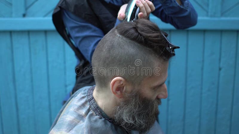 O Cabeleireiro Da Mulher Que Faz a Moderno O Corte De Cabelo Masculino Para  O Meio Envelheceu O Homem Com a Lâmina Elétrica E O P Filme - Vídeo de  habilidade, penteado: 119658502