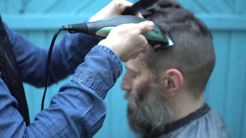 O Cabeleireiro Da Mulher Que Faz a Moderno O Corte De Cabelo Masculino Para  O Meio Envelheceu O Homem Com a Lâmina Elétrica E O P Filme - Vídeo de  habilidade, penteado: 119658502