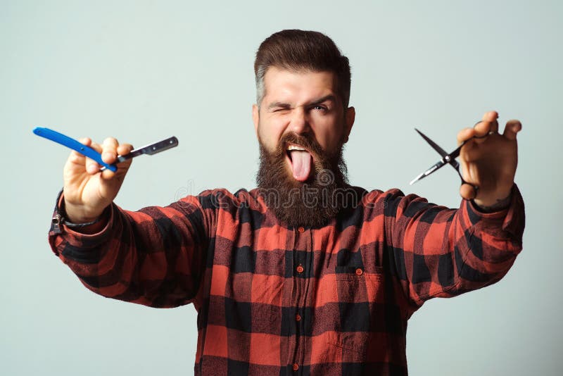 A mão de tatuagem masculina de um barbeiro profissional está segurando uma  tesoura contra uma barbearia de fundo branco e um conceito criativo de  cortes de cabelo