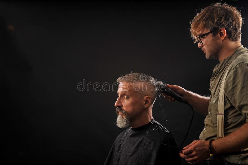 Barber cuts a beard to a client to an elderly gray-haired man royalty free stock photos Barber cuts a beard to a client to an elderly gray-haired man royalty free stock photos