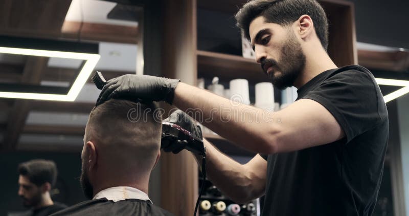 Barber cutting hair with brush and hair clipper