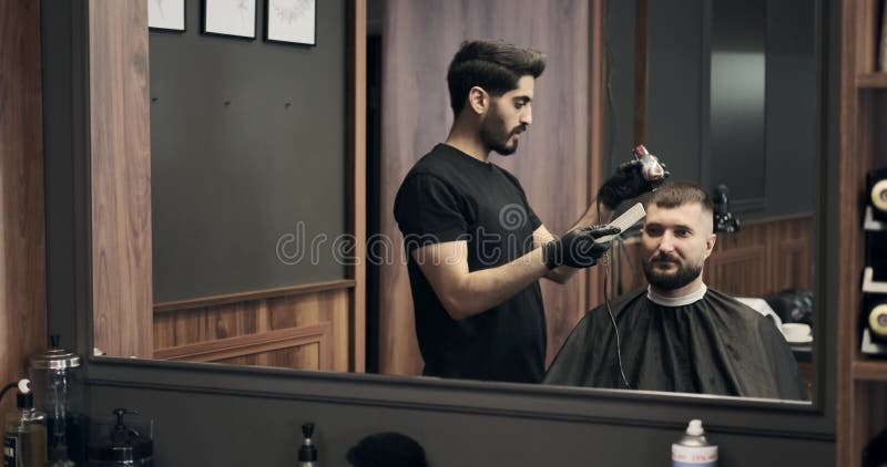 Barber cutting hair with hair clipper