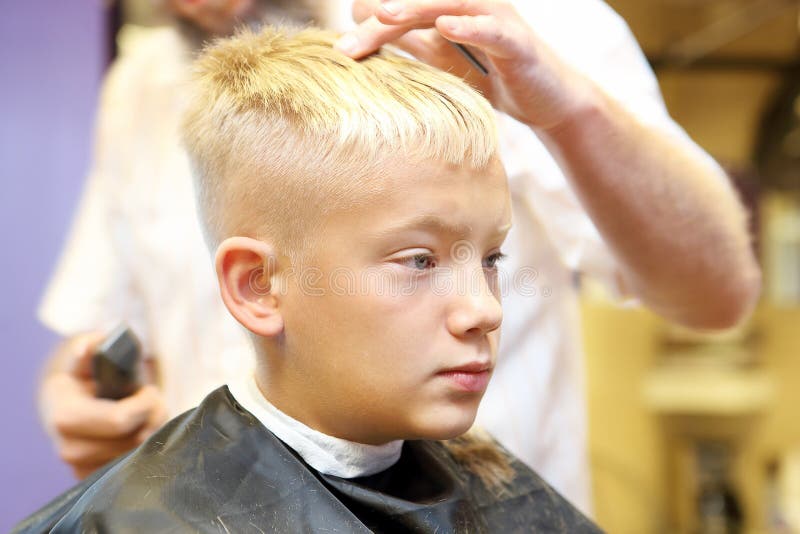 Barber Cutting Hair Of Young Boy Stock Image - Image of 