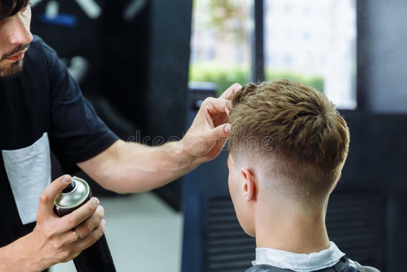 Barber Makes Hair Styling with Hair Spray after Haircut at the Barber Shop.  Young Handsome Caucasian Man Getting a Stock Image - Image of bangs, head:  153792897