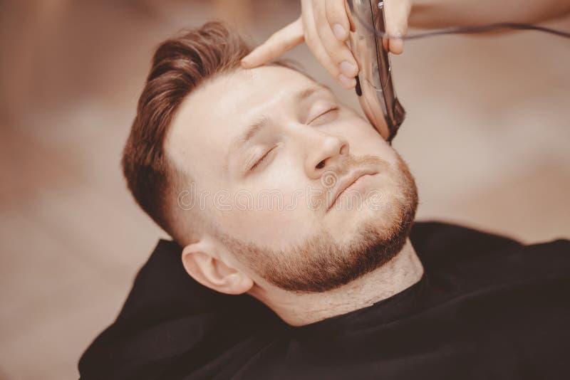 Barber shaves beard of client man on chair Barbershop stock image Barber shaves beard of client man on chair Barbershop stock image