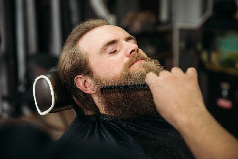 Barber using scissors and comb in barbershop stock photos Barber using scissors and comb in barbershop stock photos