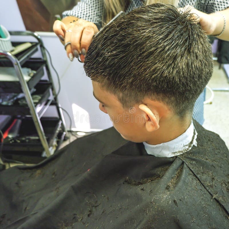 barbershop El primer de los cortes de pelo adolescente, amo hace el corte de pelo del pelo en peluquería de caballeros fotos de archivo libres de regalías barbershop El primer de los cortes de pelo adolescente, amo hace el corte de pelo del pelo en peluquería de caballeros fotos de archivo libres de regalías