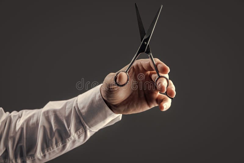 Scissors in Hand Isolated on Grey Background. Hand with Scissors Stock